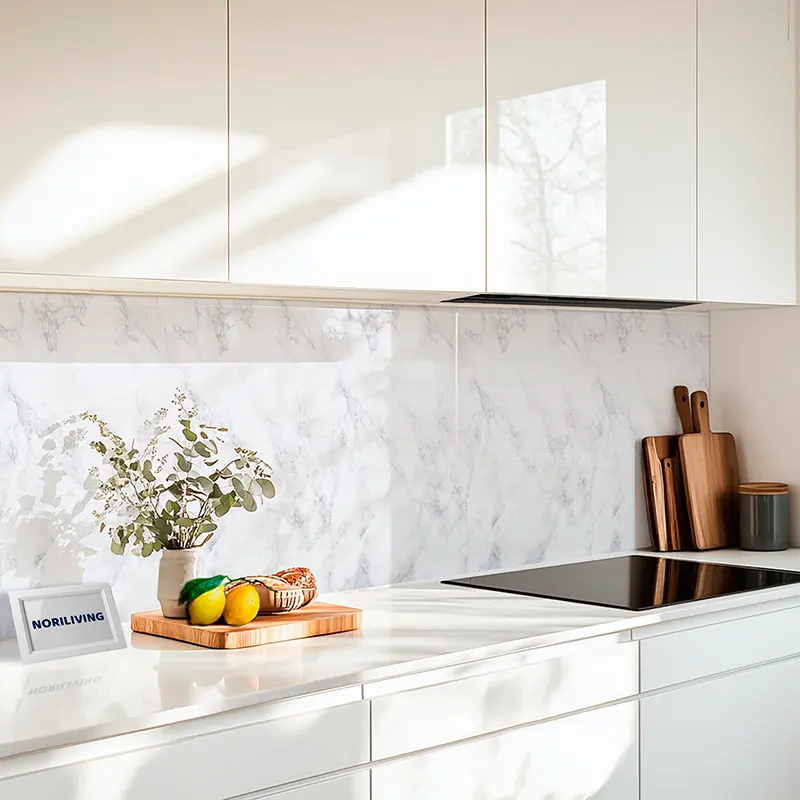 Weiße Küchenzeile mit Marmorwand, Schneidebrettern und Deko