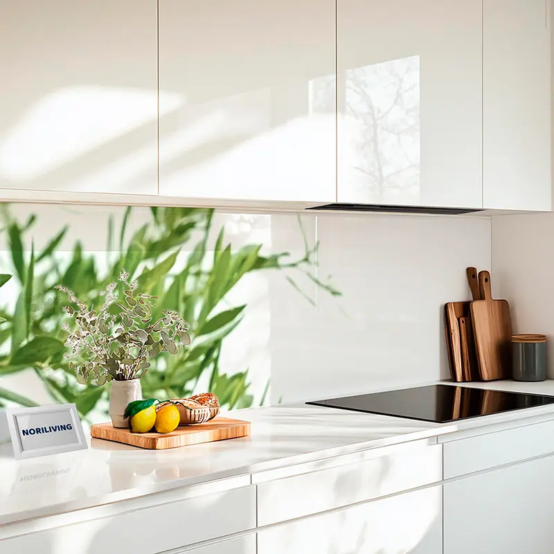 Weiße Küche mit Induktionsfeld, Holzbrett und Früchten