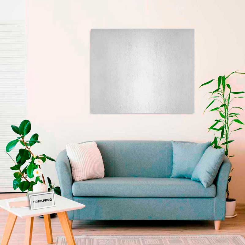 Ein gemütliches Wohnzimmer mit einer blauen Couch, dekorativen Kissen, einem kleinen Tisch mit Pflanze und einem großen Wandbild, umgeben von Zimmerpflanzen.