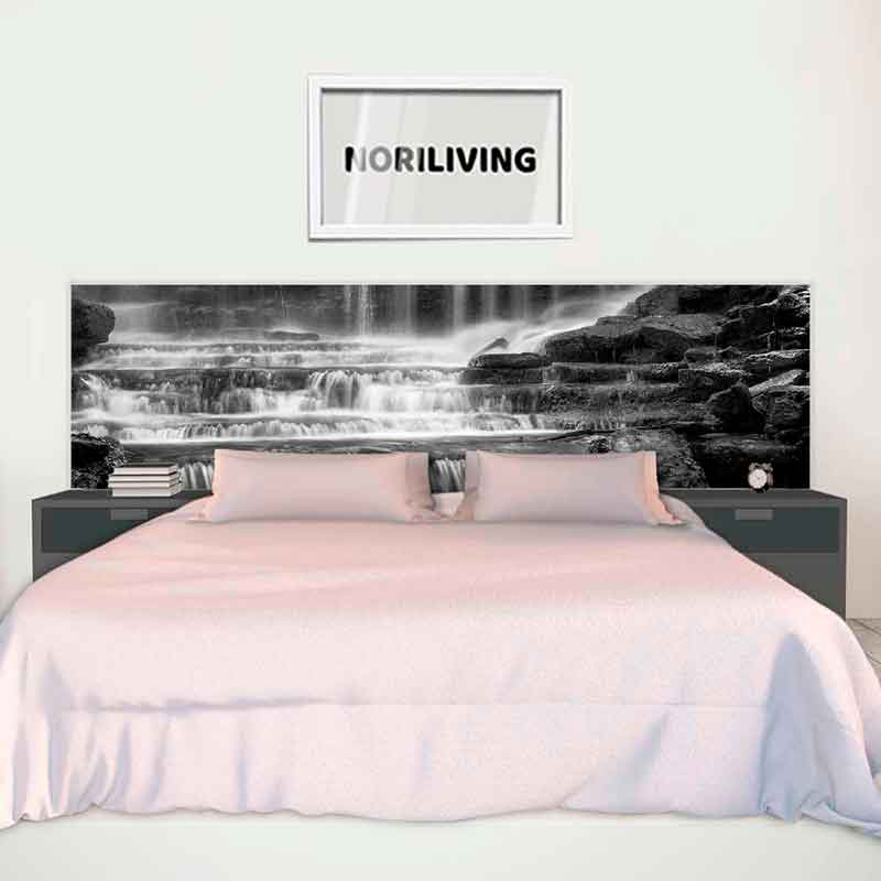 Schlafzimmer mit grauem Doppelbett, über dem eine schwarz-weiße Wasserfall-Wandbemalung und ein gerahmtes Bild zu sehen sind