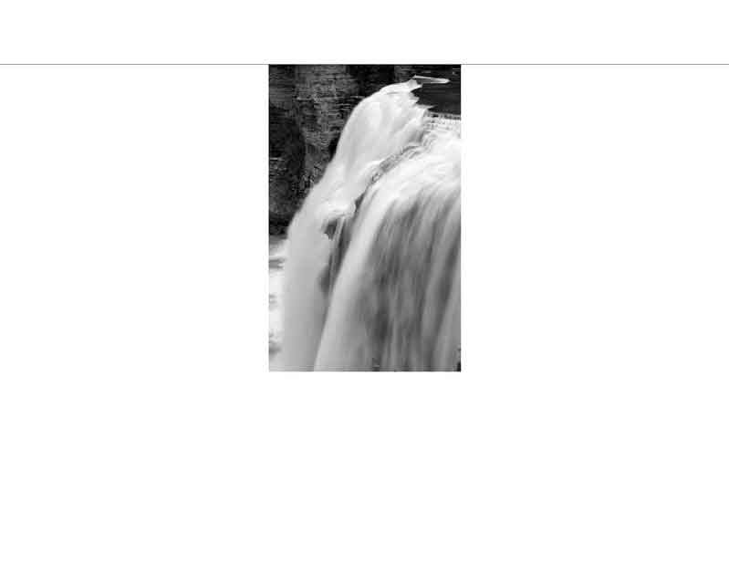 Ein beeindruckender Wasserfall in Schwarz-Weiß, der rauschend in die Tiefe stürzt.