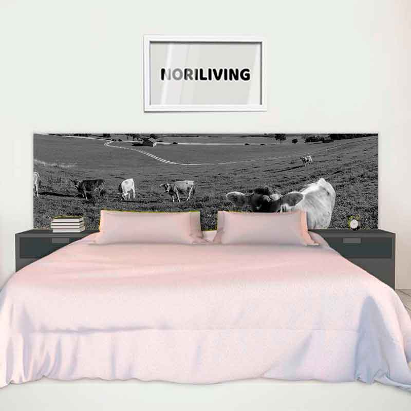 Schlafzimmer mit einem großen Bett, dekoriert mit einer Landschaftsfototapete von Kühen auf einer Weide.