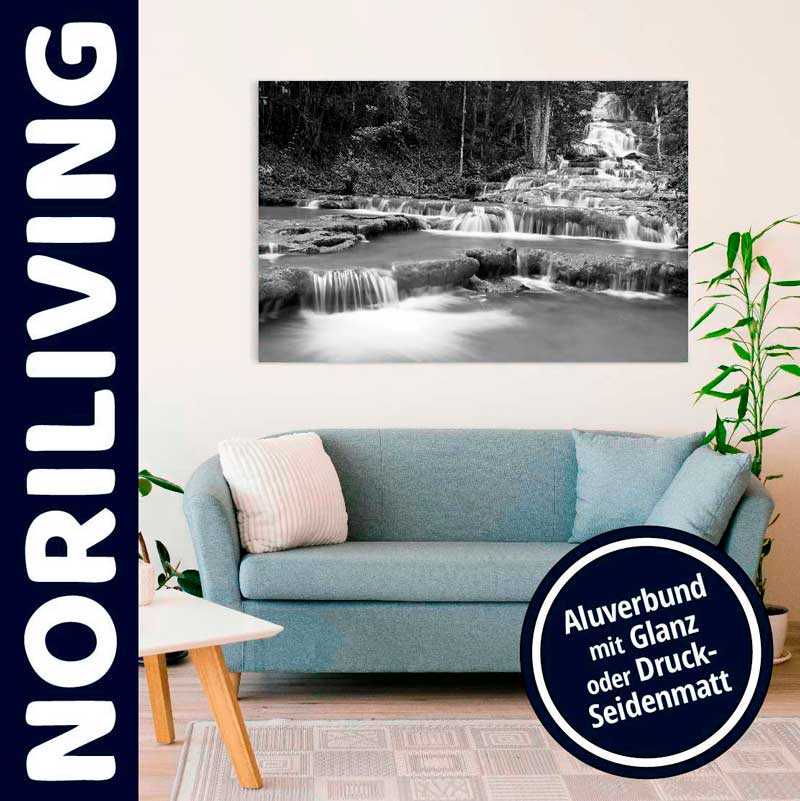 Ein gemütliches Wohnzimmer mit einem blauen Sofa und einem schwarz-weißen Wasserfall-Leinwandbild der Marke Noriliving an der Wand.