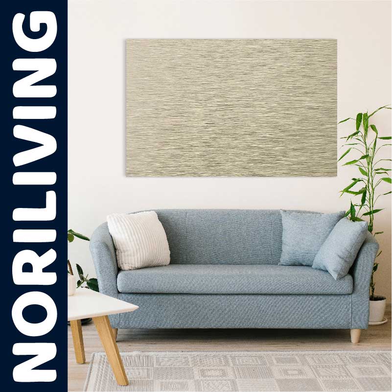 Ein elegantes Wohnzimmer mit einer blauen Couch, dekorativen Kissen, einem modernen Kunstwerk an der Wand und einer grünen Pflanze im Hintergrund