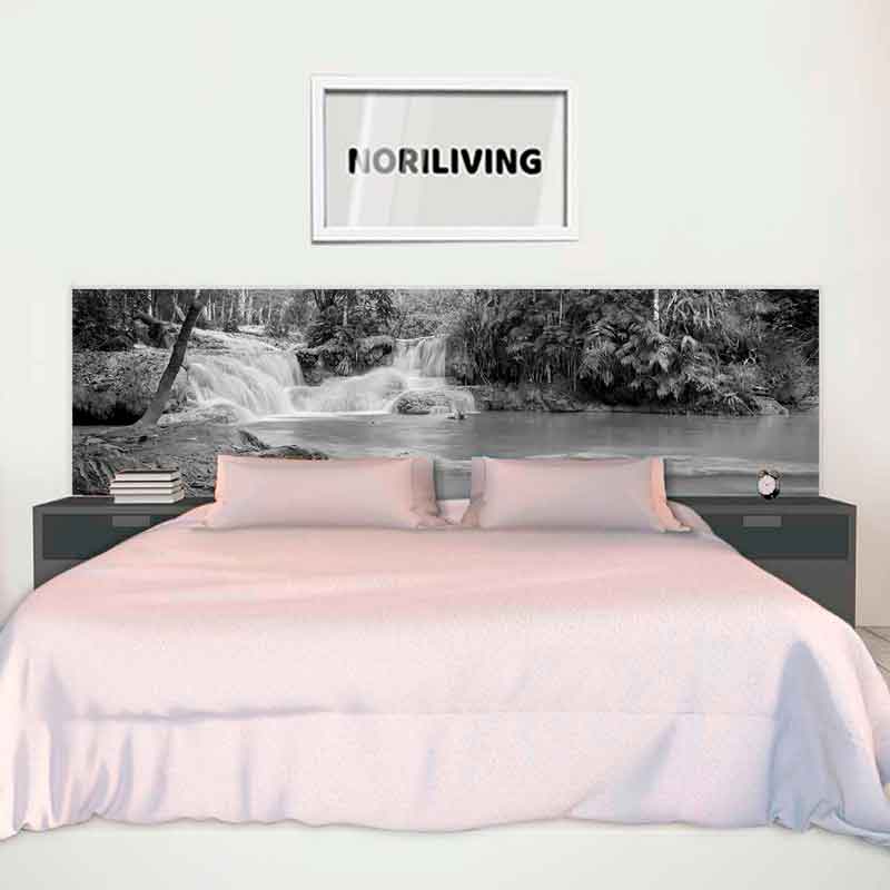 Modernes Schlafzimmer mit einem großen Bett mit rosa Tagesdecke, flankiert von zwei Nachttischen und einem Wandbild von Wasserfällen über dem Bett