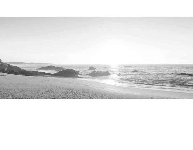 Sonnenaufgang an einem einsamen Strand mit Meerblick und Felsen im Hintergrund