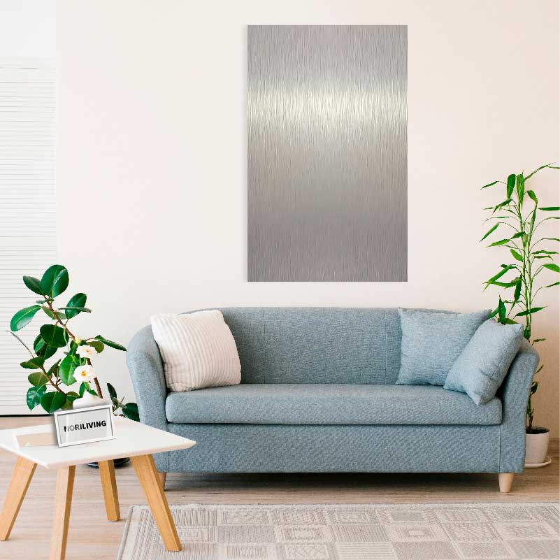 Ein stilvolles Wohnzimmer mit blauer Couch, weißen Kissen und einem großen Metallbild an der Wand. Pflanzen stehen neben der Couch und auf einem weißen Holztisch.