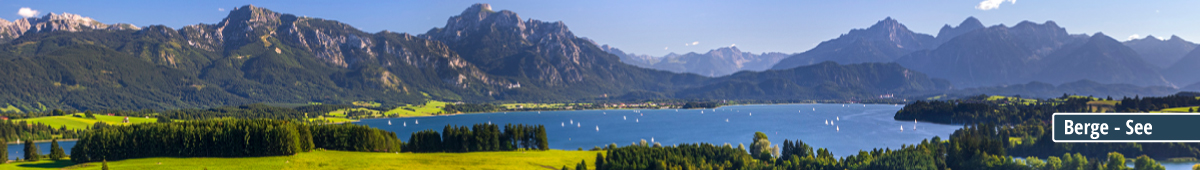 Idyllische Berglandschaft mit einem See und Segelbooten im Vordergrund