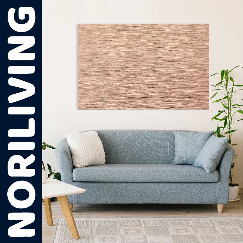 Ein stilvolles Wohnzimmer mit einer blauen Couch, Zierkissen und einem Holzwandbild im Hintergrund. Pflanzen und ein heller Teppich ergänzen das Ambiente.